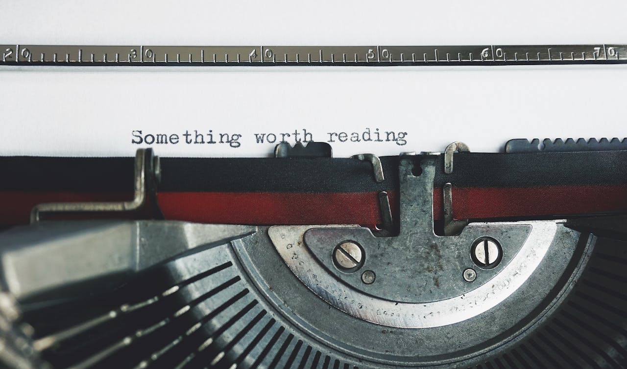 Close-up of a vintage typewriter with the phrase Something worth reading.